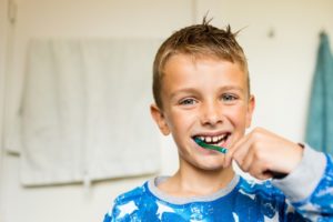 Young boy brushing this teeth in his pjs