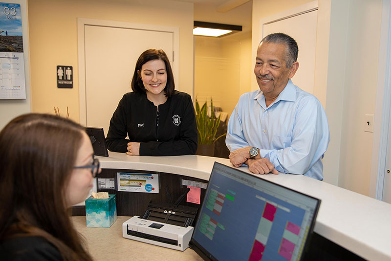 Patient being helped at the front desk within the dental practice