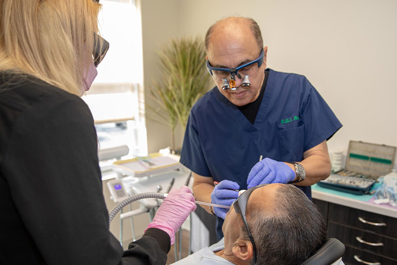 doctor performing dental procedure with patient within the dental practice